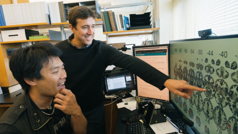 Professor pointing at screen with student